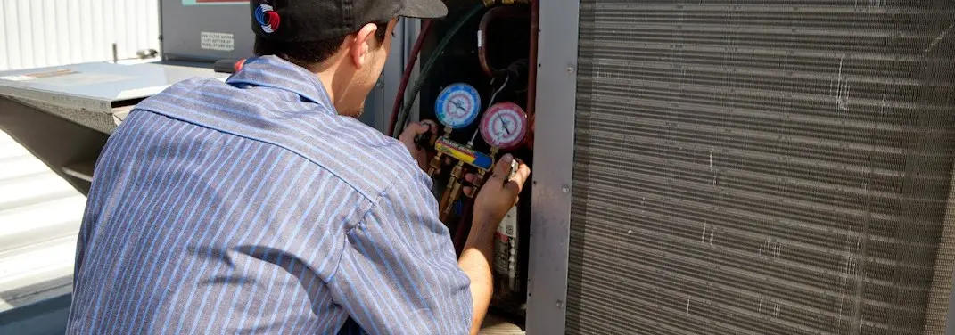 HVAC technician servicing a condenser unit in Rutherford